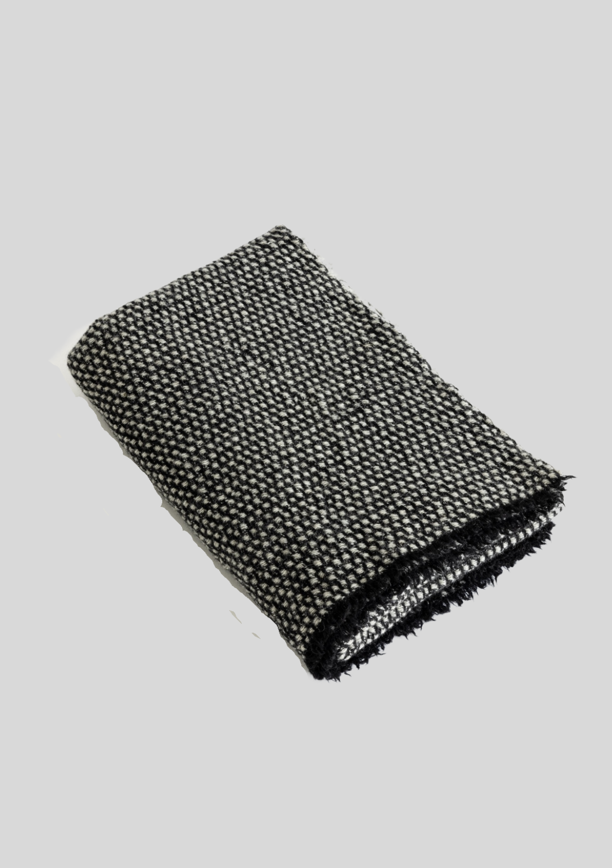 Textured pattern grey and black colored throw made out of responsible sheep wool. Manufactured in Finland.  