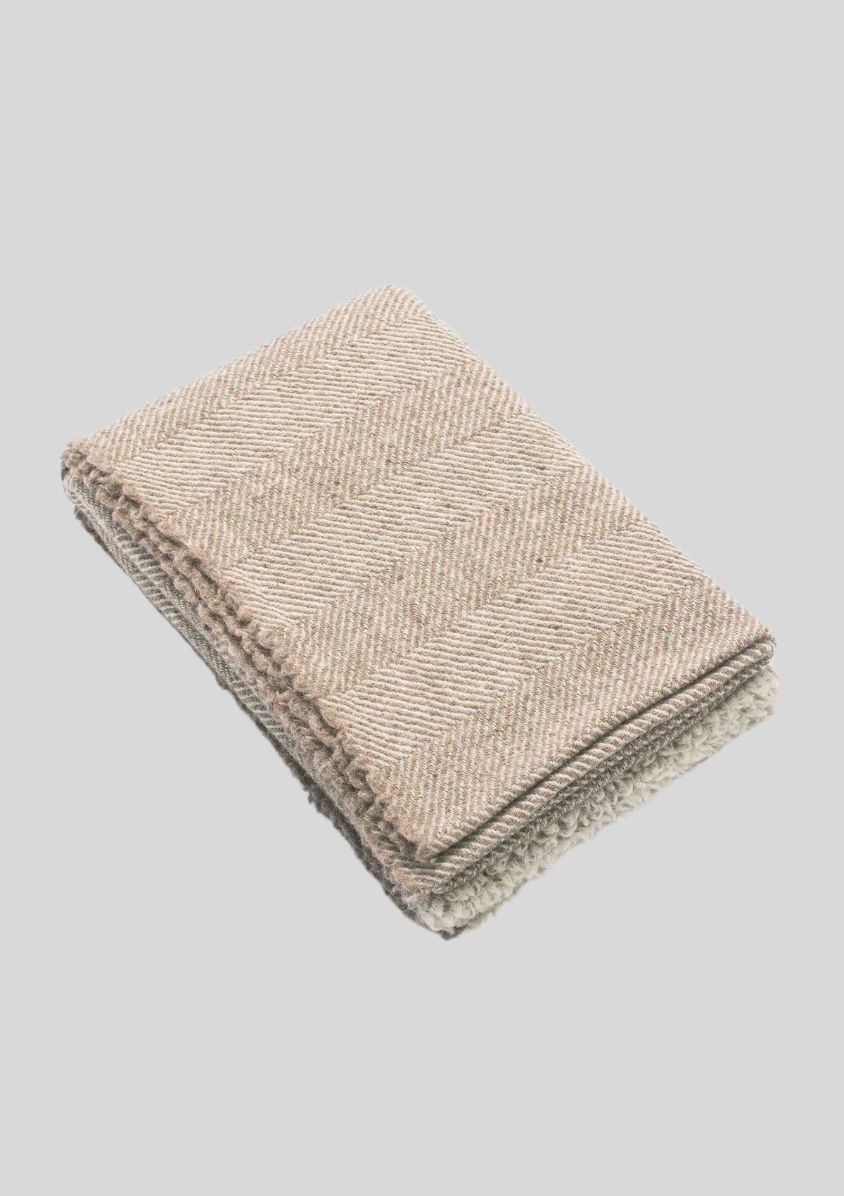 Herringbone pattern white and beige colored throw made out of responsible Finnish sheep wool. Manufactured in Finland.  