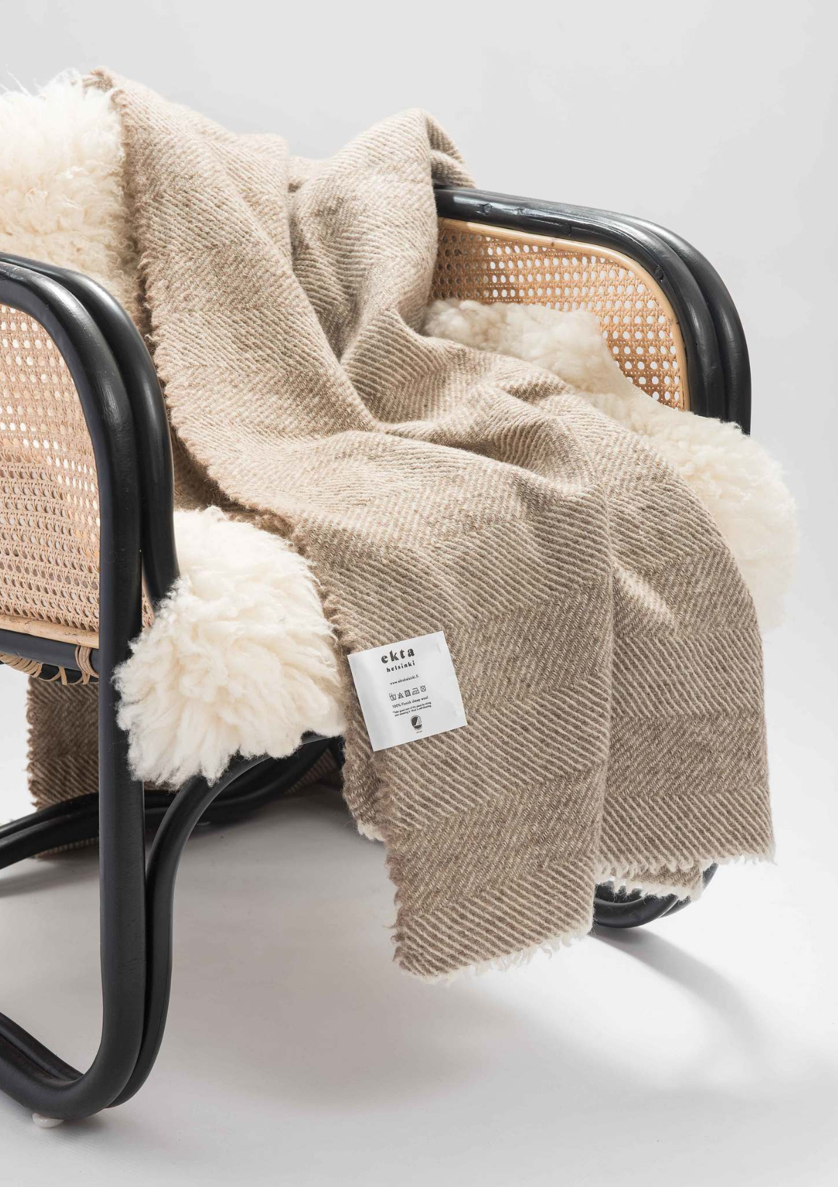 Herringbone pattern white and beige colored throw made out of responsible Finnish sheep wool. Manufactured in Finland.  